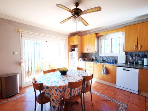 a kitchen with a table and a ceiling fan at Gibraltar Views Guest House in La Línea de la Concepción
