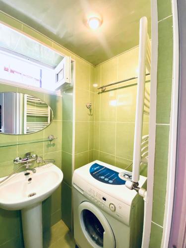 een kleine badkamer met een wasmachine en een wastafel bij avlabari in Tbilisi City