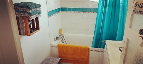 a bathroom with a tub and a shower with an orange towel at Chambre en duplex proche mer in Saint-Nazaire