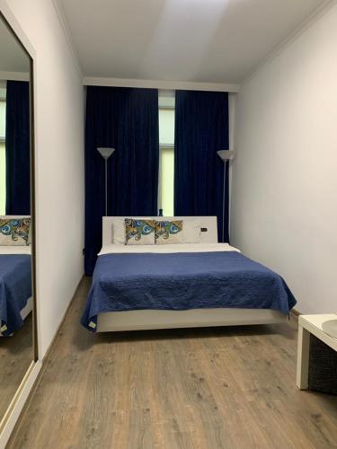 リヴィウにあるLviv-centre apartments Gorodotska 44のベッドルーム1室(青いシーツと鏡付きのベッド1台付)