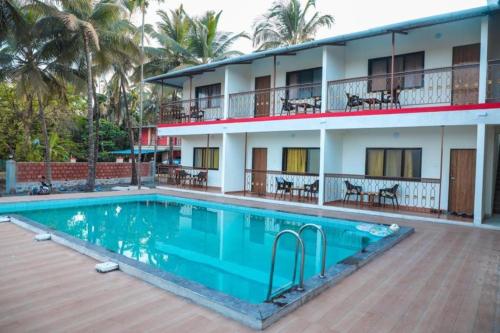 a hotel with a swimming pool in front of a building at Mokalbaug Beach Resort in Nagaon