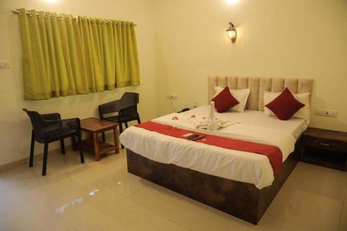 a bedroom with a large bed and a table and chairs at Mokalbaug Beach Resort in Nagaon