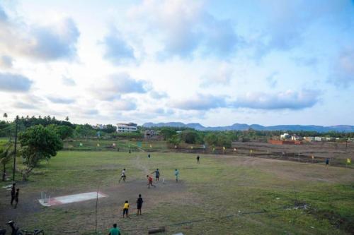 a group of people playing a game in a field at Mokalbaug Beach Resort in Nagaon