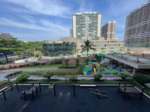 a park with a playground in a city with buildings at Flat Barra - Parque das Rosas in Rio de Janeiro