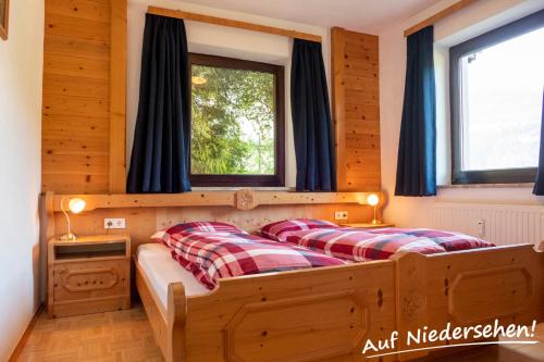 two beds in a room with two windows at Auf Niedersehen Apartment National Park Höhe Tauern in Hollersbach im Pinzgau