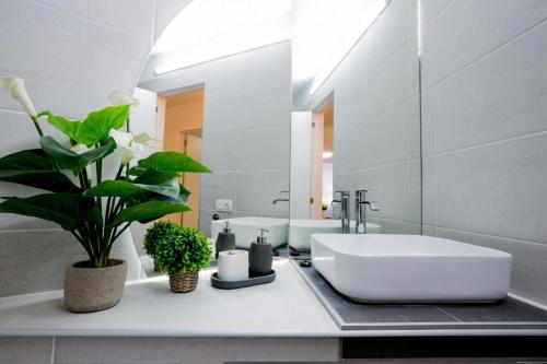 Baño blanco con lavabo y espejo en GP127 apartman Tenerife, en San Miguel de Abona