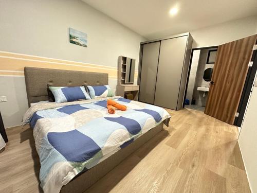 a bedroom with a bed with a blue and white comforter at Wanderlust Homes @ Armadale Residence in Kuching