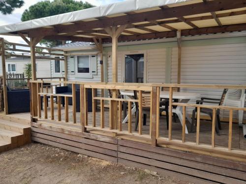 une terrasse avec une pergola et une table dans l'établissement Location Mobil home Camping Pédro, au Grau-dʼAgde