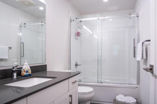 y baño blanco con lavabo y ducha. en Granite Ridge Condo by Revelstoke Vacations en Revelstoke