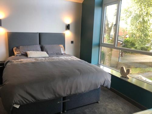 ein Schlafzimmer mit einem großen Bett und einem Fenster in der Unterkunft Welcome to your stay The Nest in Bolton