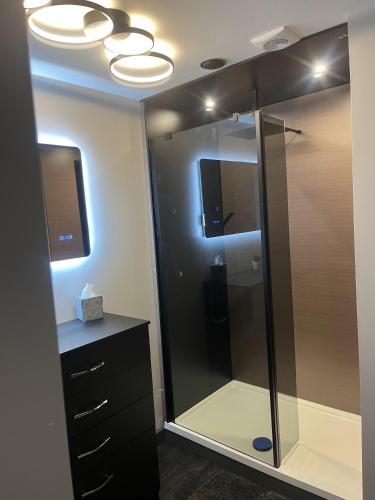 a bathroom with a glass shower with a tv in it at Welcome to your stay at The Nest in Bolton