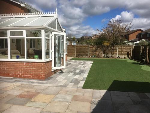 a garden with a lawn in front of a house at Welcome to your stay at The Nest in Bolton