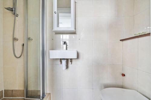 La salle de bains est pourvue de toilettes, d'un lavabo et d'une douche. dans l'établissement Charming Flat In Shepherds Bush, à Londres