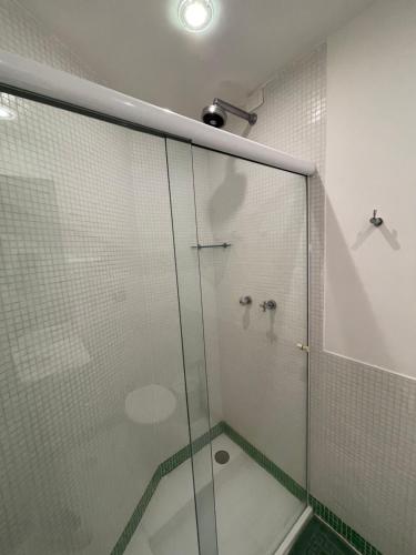 a shower with a glass door in a bathroom at Acomodações do Tio Will - 2 in Guarujá