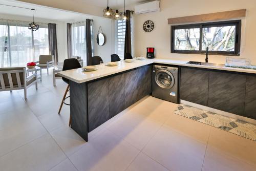 een keuken met een wasmachine in het midden van een kamer bij OceanBreeze Apartments Mont Choisy in Mont Choisy