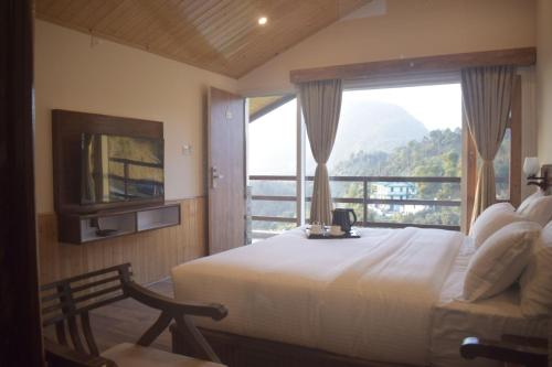 a bedroom with a large bed and a large window at The Stone Age : a boutique hotel in Shimla