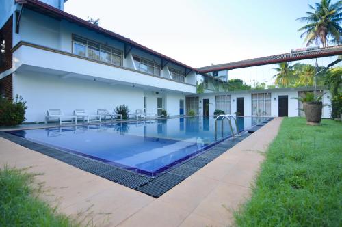 a swimming pool in front of a house at Siyanco Holiday Resort in Polonnaruwa