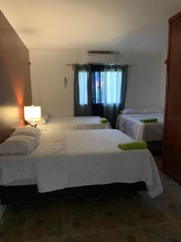 um quarto com duas camas e um candeeiro no chão em Complejo Deportivo Wilson Palacios em La Ceiba