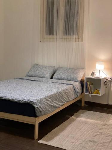 łóżko z 2 poduszkami i stół z lampką w obiekcie Homey Apt. with beautiful view w mieście Amman