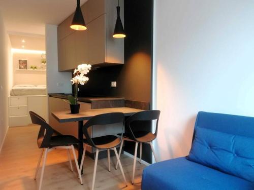 a kitchen with a table and chairs and a blue couch at Monolocale Niki - Holiday Home in Trento