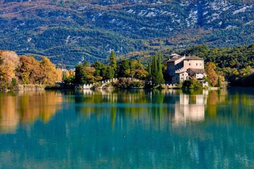 a house on a island in the middle of a lake at Monolocale Niki - Holiday Home in Trento