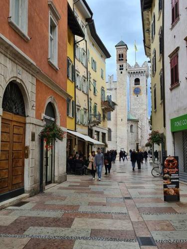 a group of people walking down a street with buildings at Monolocale Niki - Holiday Home in Trento