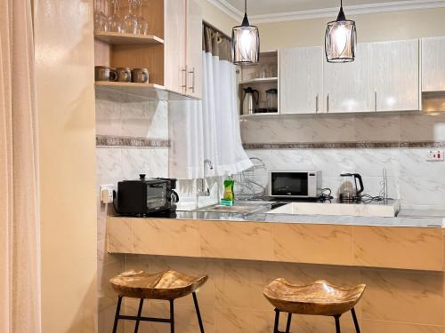 Luxurious 2 bedroom penthouse-Fully Furnished في كيتالي: مطبخ مع كونتر فيه كرسيين