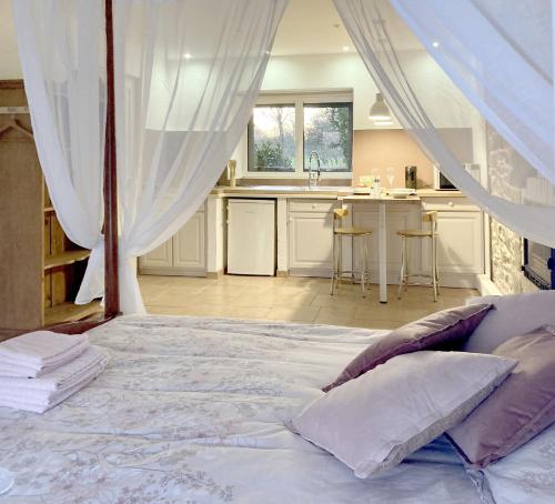 une chambre avec un grand lit et une cuisine dans l'établissement Domaine de la Tranquillité R, à Noyal-Muzillac