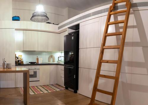 uma cozinha com uma escada e um frigorífico preto em NEWWWWW THISSEION LOFTS GEORGE em Atenas