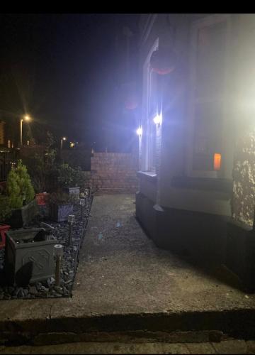 a building with lights on the side of it at night at Butterfly House in Blackwood