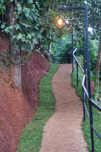 a path with a light on the side of a fence at TREE6 WAYANAD in Vythiri