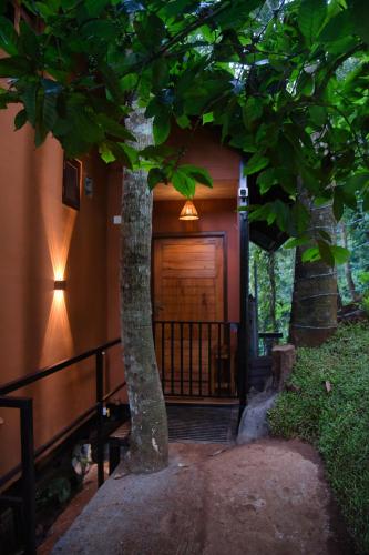 a house with a tree in front of it at TREE6 WAYANAD in Vythiri