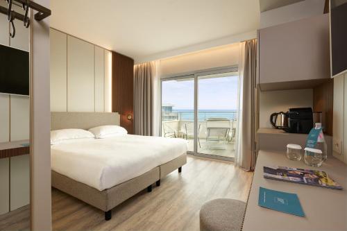 a bedroom with a bed and a view of the ocean at Adriatic Palace Hotel in Lido di Jesolo