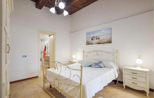Un dormitorio con una cama blanca y una pintura en la pared en Cozy Home In Giungano With Wi-fi, en Giungano