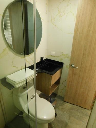 a bathroom with a toilet and a mirror at HOTEL MX BOGOTA in Bogotá