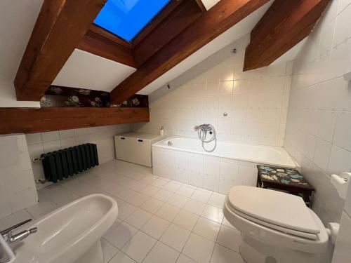 a bathroom with a toilet and a bath tub at Maison Ricci in Oulx
