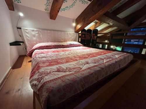 - une chambre avec un lit et une couette rouge dans l'établissement Maison Ricci, à Oulx