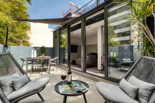 a patio with chairs and a table with a wine glass at ULIV Park Polanco in Mexico City