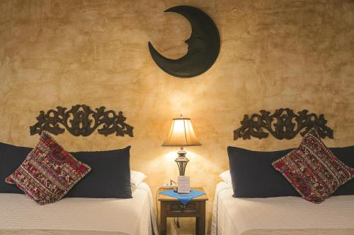 a bedroom with two beds and a crescent moon on the wall at Hotel Posada de la Luna in Antigua Guatemala