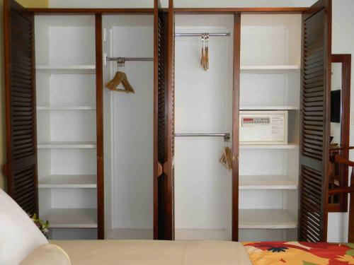 a room with a closet with shelves and a bed at Hotel Residence Inn Suites Cristina in San José
