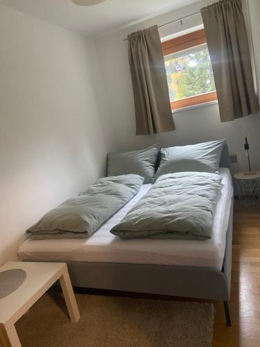 a bed in a room with two pillows and a window at Appartment Rosennock in Sankt Oswald