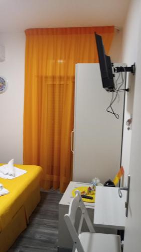 a room with a bed and a television and a desk at Il Paradiso di Marilyn in Milazzo