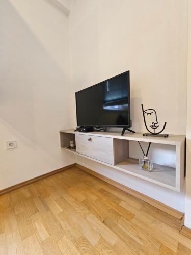 a living room with a flat screen tv on a shelf at EApartments in Skopje