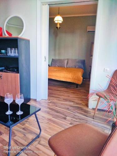 a living room with a couch and two wine glasses on a table at Central Sophisticated Studio Pyrgos near Olympia in Pýrgos