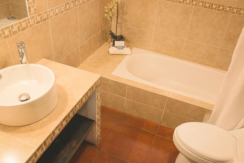 a bathroom with a sink and a toilet and a tub at Hotel Posada de la Luna in Antigua Guatemala
