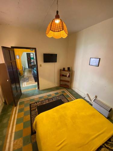um quarto com uma cama amarela e uma televisão em ESTUDIO EN EL ZOCALO DE TLAXCALA em Tlaxcala de Xicohténcatl