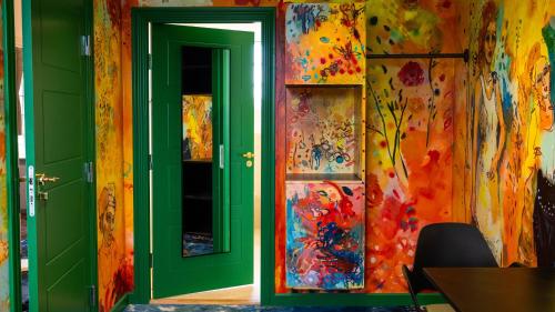 a room with a green door and a colorful wall at ART Hotel Dalgas, BW Signature Collection in Brande