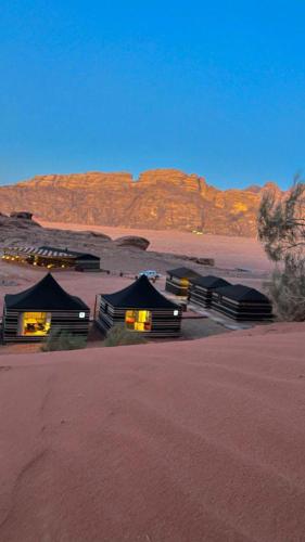 een groep hutten midden in de woestijn bij SOlARIS WADI RUM CAMP in Wadi Rum