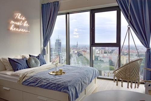 Un dormitorio con una cama y una ventana grande. en Apartament Heaven Hanza Tower 17th floor, en Szczecin