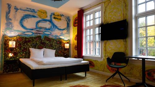 - une chambre avec un lit et une peinture murale dans l'établissement ART Hotel Dalgas, à Brande